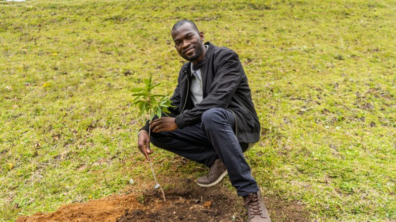Photo of Faith Abiodun posing to the camera with a tree planted on UWC Costa Rica's future new campus