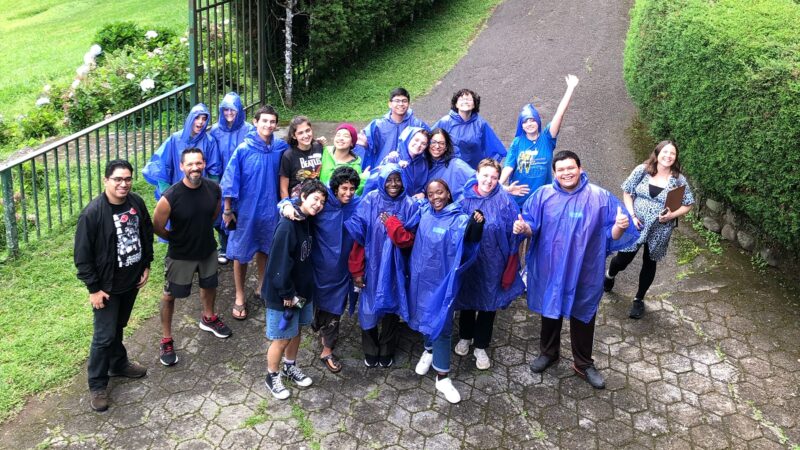 Group photo os students and facilitator all wearing rain coats in the San Isidro Campus
